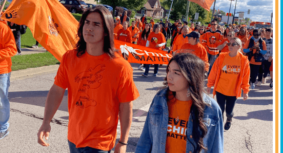 A young man and woman participate in an Every Child Matters Walk.